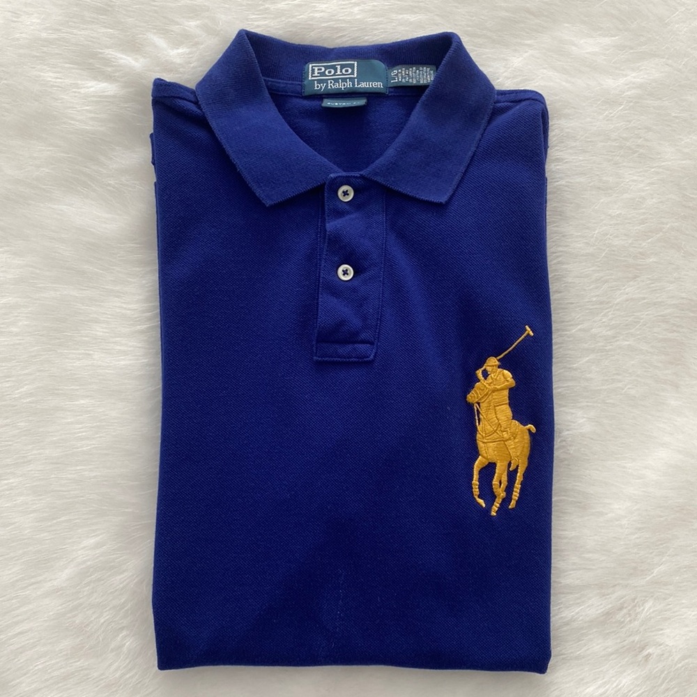 Blue polo short sleeve shirt with gold embroidery.